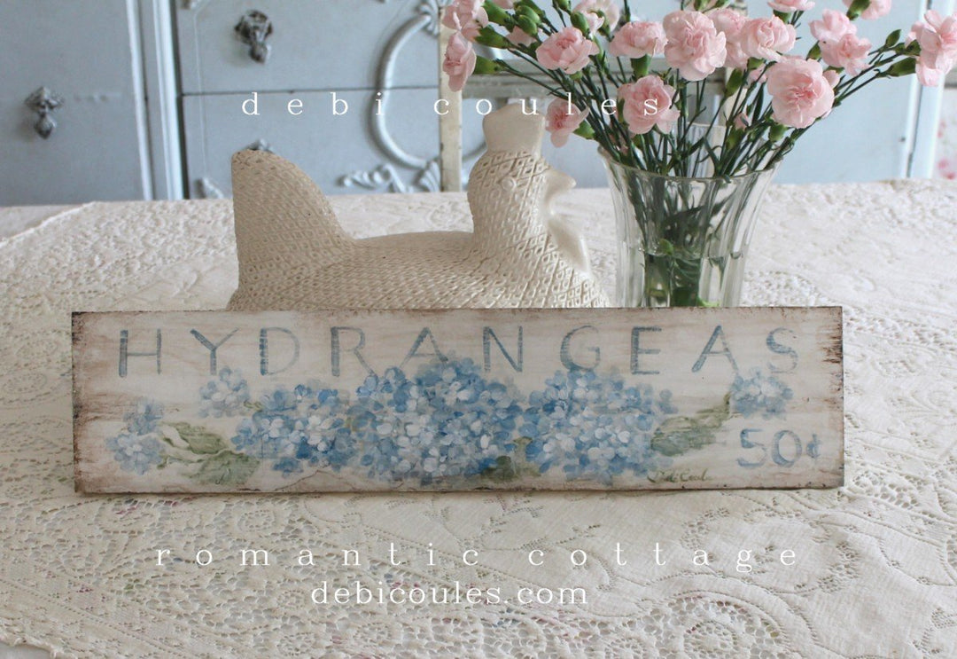 Beautiful Blue Hydrangeas on an antique white, distressed, vintage shabby chic style background. Also works with modern farmhouse. The writing states: Hydrangea bouquets 50 cents. A rustic wooden sign that would be great in kitchen, bath, or anywhere